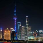 上海旅遊攻略懶人包:景點、美食、行程一次看懂 Illuminated Shanghai skyline featuring the Oriental Pearl Tower against a night sky.