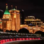 A group of people sitting on a bench in front of a city
