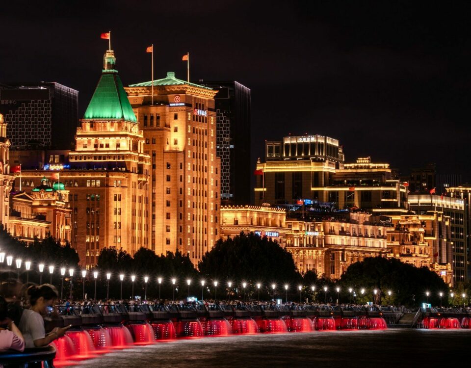 A group of people sitting on a bench in front of a city
